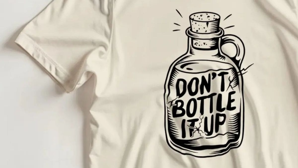 T-shirt featuring a hand-drawn bottle illustration with the words “Don’t Bottle It Up” printed in bold black lettering.